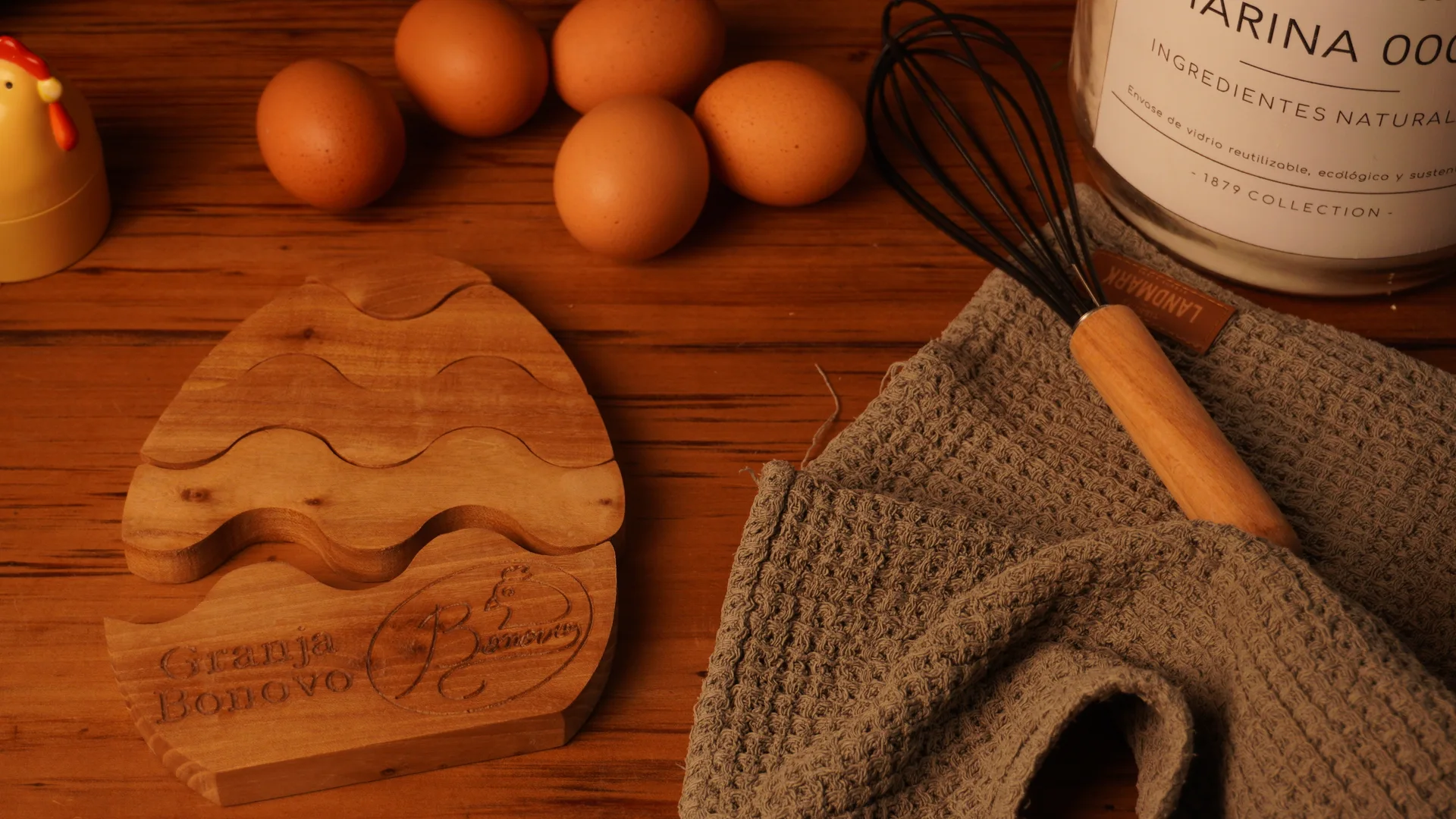 Huevos sobre una mesa de madera junto a utensilios de cocina